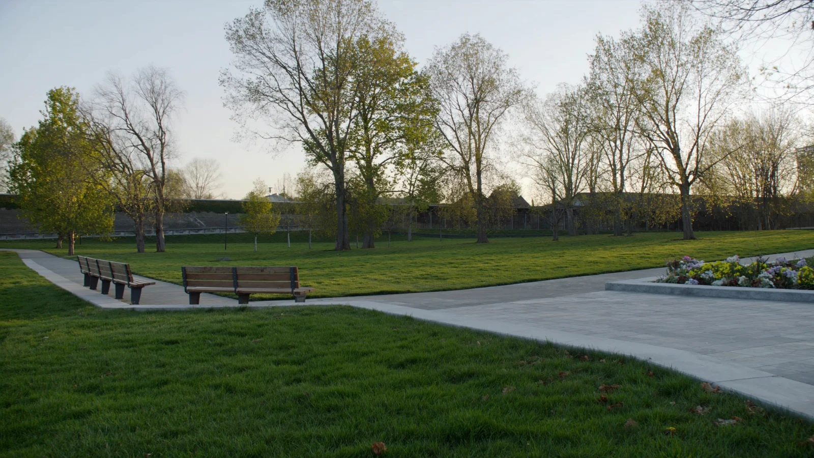 Parque urbano com área verde e caminho pavimentado no bairro